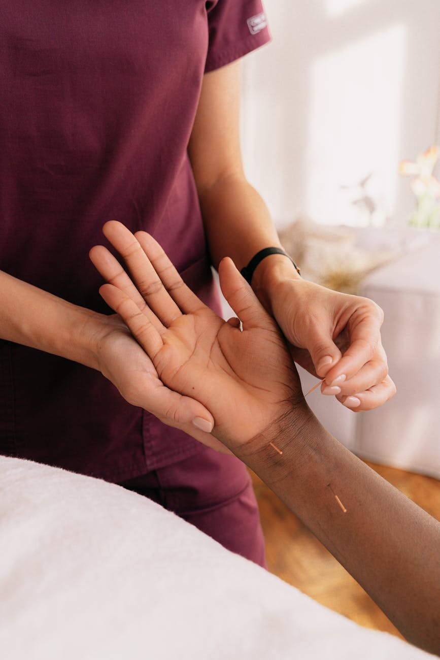 Acupuncturist examining patient's wrist for pulse diagnosis in traditional Chinese medicine
